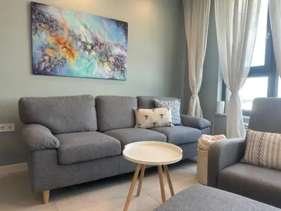 a living room with a couch and a painting on the wall at Апартамент В 48 в Сграда МОНА in Sofia