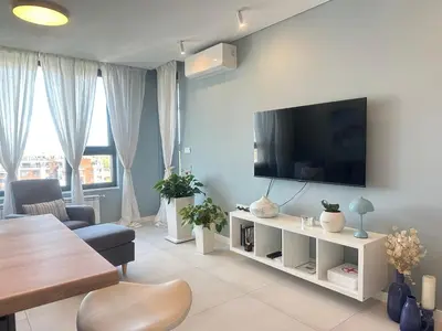 a living room with a flat screen tv on a wall at Апартамент В 48 в Сграда МОНА in Sofia