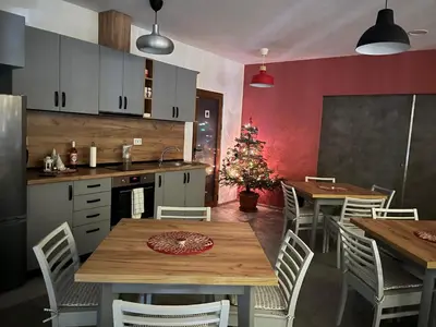 a kitchen with a table and chairs and a christmas tree at Villa YoSi - apartments in Sapareva Banya