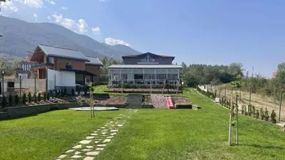 a large house with a lawn in front of it at Villa YoSi - rooms in Sapareva Banya