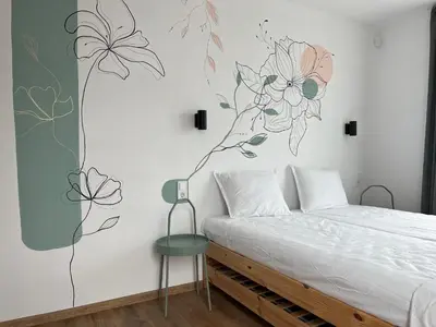 a bedroom with a bed with a flower mural on the wall at Villa YoSi - rooms in Sapareva Banya
