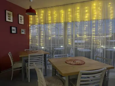 a dining room with tables and chairs and a window at Villa YoSi - rooms in Sapareva Banya