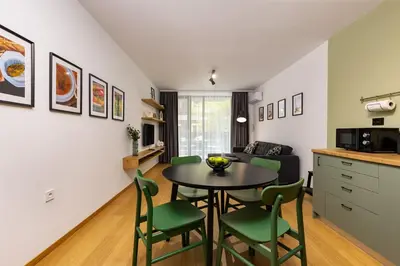 a kitchen and living room with a table and chairs at Stylish apt 'Photo Booth' with an amazing location in Plovdiv