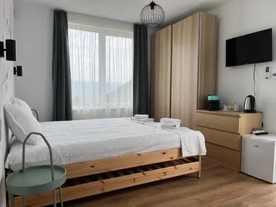 a bedroom with a bed with a chair and a tv at Villa YoSi in Sapareva Banya