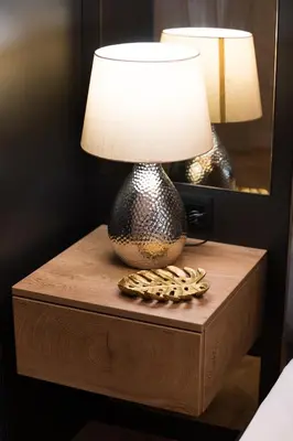 a table with a lamp on a night stand at Луксозен арт апартамент в близост до центъра на града in Sofia