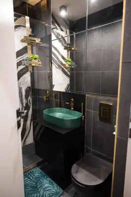 a bathroom with a green sink and a toilet at Луксозен арт апартамент в близост до центъра на града in Sofia