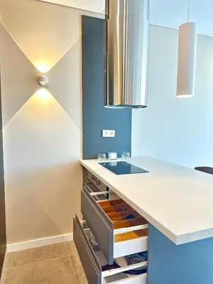 a kitchen with a counter and a blue wall at Апартамент В 54 в Сграда МОНА in Sofia