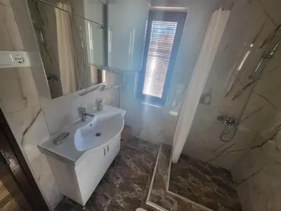 a white bathroom with a sink and a shower at Йони in Teteven
