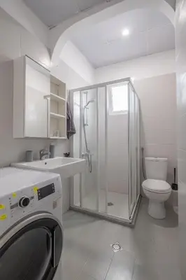 a bathroom with a shower toilet and a washing machine at Spacious & Central 2BR with Terrace, Cozy & Modern by Flat Mаnager in Sofia