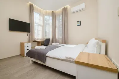 a bedroom with a bed and a desk and a television at Cozy Corner-Heart of Plovdiv in Plovdiv