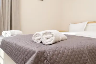 a bed with two towels on top of it at Cozy Corner-Heart of Plovdiv in Plovdiv