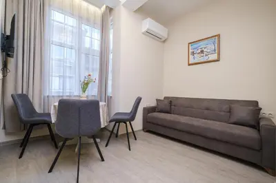 a living room with a couch and a table and chairs at Cozy Corner-Heart of Plovdiv in Plovdiv