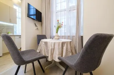 a dining room with a table and chairs and a window at Cozy Corner-Heart of Plovdiv in Plovdiv