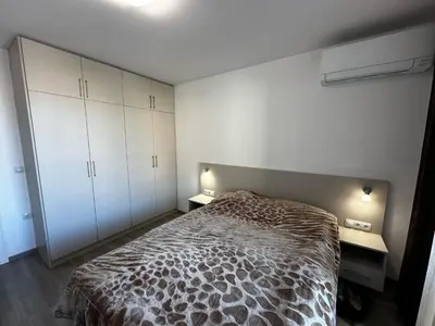 a bedroom with a bed and two tables and cabinets at Apartment Aria 6 in Velingrad