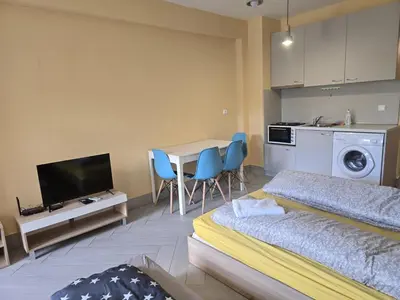 a room with two beds and a table and a kitchen at Green Oasis in Sofia