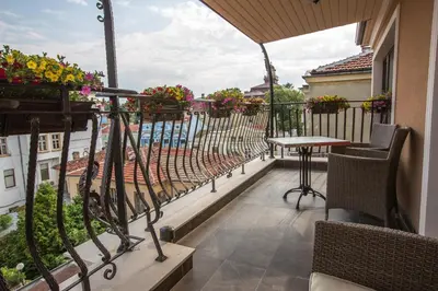 a balcony with a table and chairs and a view of the water at 8 1/2 Art Guest House in Plovdiv