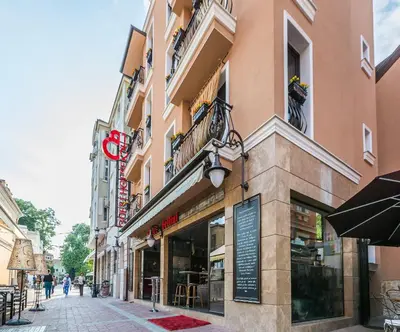 a building with a sign on the side of a street at 8 1/2 Art Guest House in Plovdiv