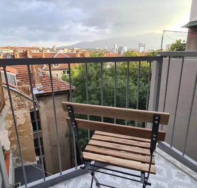 a wooden bench sitting on top of a balcony at Central 1-Bedroom Apartment with Balcony & View in Sofia