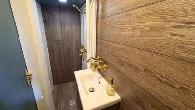 a bathroom with a sink and a wooden wall at Central 1-Bedroom Apartment with Balcony & View in Sofia