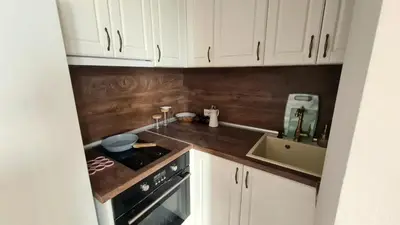 a kitchen with white cabinets and a stove and a sink at Central 1-Bedroom Apartment with Balcony & View in Sofia