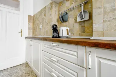 a kitchen with white cabinets and a counter top at Classic Charm - 2BD central Apartment by FlatManager in Sofia