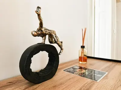 a metal sculpture of a man on a tire on a table at Classic Charm - 2BD central Apartment by FlatManager in Sofia