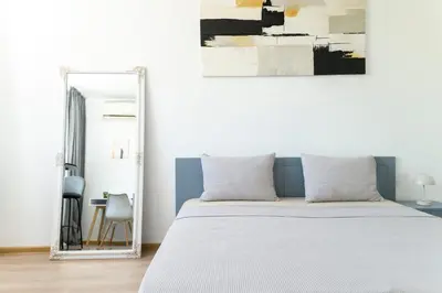 a bedroom with a large bed and a mirror at Sunny Top Floor Apartment near Tokuda Hospital & Paradise Mall in Sofia