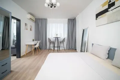 a hotel room with a large bed and a table at Sunny Top Floor Apartment near Tokuda Hospital & Paradise Mall in Sofia