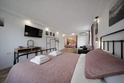 a bedroom with a large bed and a living room at Villa High Point in Pravets