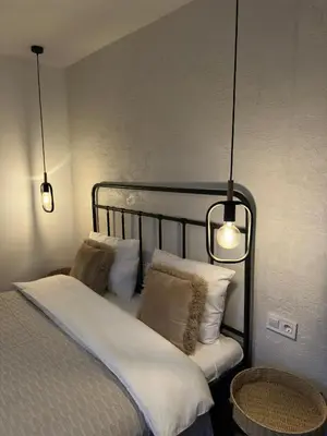 a bedroom with a bed with white pillows and two lights at Villa High Point in Pravets