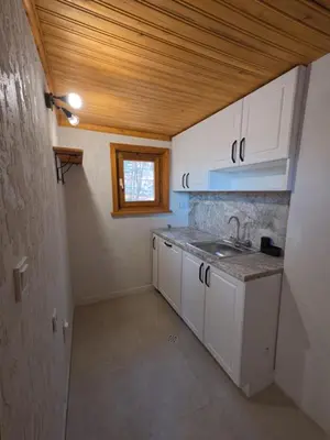 a small kitchen with white cabinets and a sink at Villa High Point in Pravets