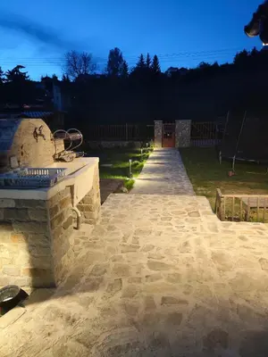 a stone pathway in a yard at night at The Bird Villa in Bosnek