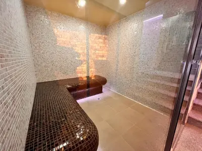 a bathroom with a shower with a bench in it at Ardo Hill Spa Hotel and Restaurant in Sarnitsa