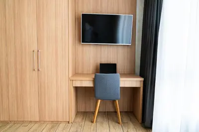 a desk with a chair and a tv on a wall at Business Park Premium, 2B lux flat, free garage in Sofia