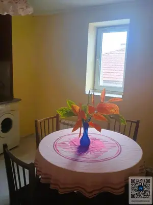 a table with a blue vase with a plant on it at Uspeh bg in Plovdiv