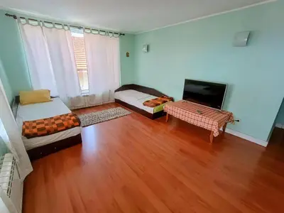 a living room with wooden floors and a large window at Uspeh bg in Plovdiv