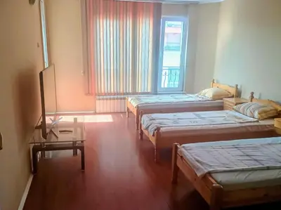 a room with three beds and a window at Uspeh bg in Plovdiv