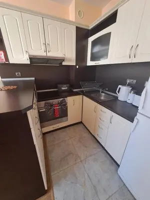 a small kitchen with white cabinets and a sink at Apartment-10 min from Sofia airport in Sofia