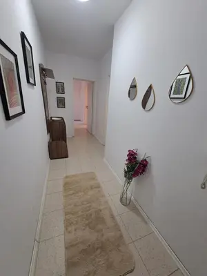 a hallway with white walls and a vase of flowers at Apartment-10 min from Sofia airport in Sofia