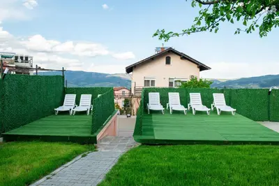 a group of white chairs sitting on top of a yard at Къща Инфинити Лукс и Уют, Вплетени в Спомени in Sapareva Banya
