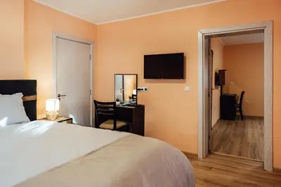 a hotel room with a bed and a desk and a television at Апартамент Инфинити in Sapareva Banya