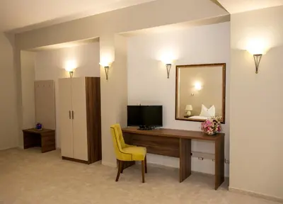 a room with a desk with a television and a mirror at Hotel Monte Cristo in Blagoevgrad