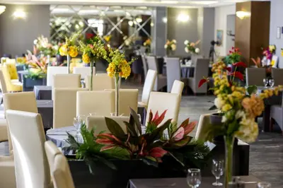 a dining room with tables and chairs with flowers on them at Hotel Monte Cristo in Blagoevgrad