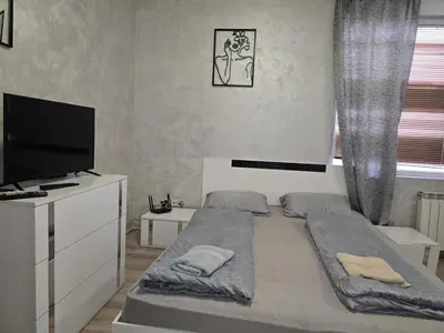 a bedroom with two beds and a flat screen tv at The Alma Mater in Sofia