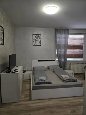 a bedroom with a bed and a desk with a computer at The Alma Mater in Sofia