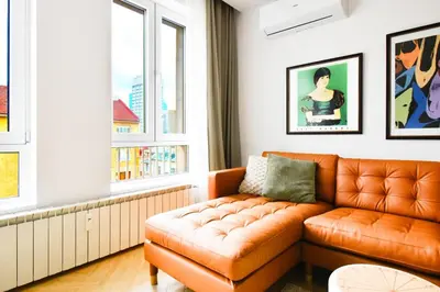 an orange couch in a living room with windows at For Those Who Want the Best City Views and Style in Sofia