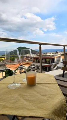 two glasses of wine sitting on a table on a balcony at Арт мезонет под тепето in Plovdiv