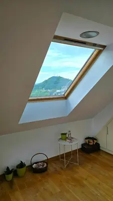 a room with a skylight in the ceiling with a table at Арт мезонет под тепето in Plovdiv