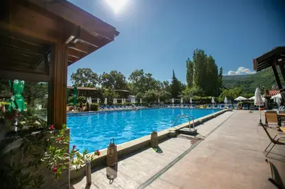 a large swimming pool with blue water in a resort at Комплекс Варвара - Хотел и Минерални басейни in Varvara