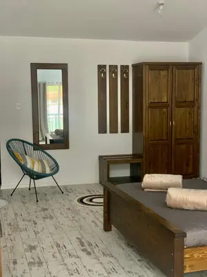 a bedroom with a bed and a chair and a mirror at Комплекс Варвара - Хотел и Минерални басейни in Varvara